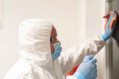 Temizlik personeli kovid19 'dan kaçınmak için okul kapılarını dezenfekte ediyor