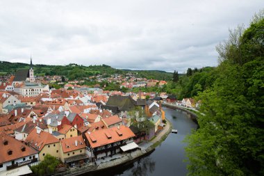 Kilisenin ünlü Cesky Krumlov Şatosu 'nun bulunduğu tarihi Cesky Krumlov şehrinin yukarıdaki panoramik manzara manzarası, ilkbaharda güzel bir gökyüzü ve bulutlarla yakalanan UNESCO Dünya Mirası Alanında yer alıyor.