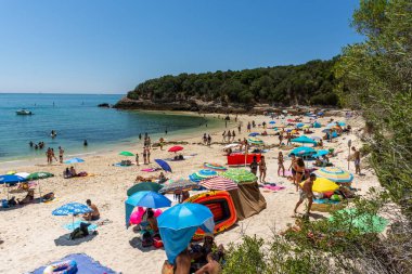 Setubal, Lizbon, Portekiz yakınlarında güneşli bir günde turist ve şemsiyelerle sahile güzel bir manzara