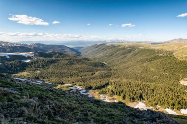 Dağları ve mavi gökyüzü olan güzel bir manzara.