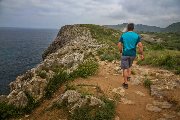Man walking on the cliffs in Asturias (Spain) with blue t-shirt