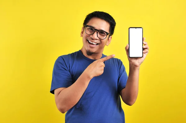 Szczęśliwy Azjata Pokazuje Ekran Telefonu Wskazując Izolowany Żółtym Tle — Zdjęcie stockowe
