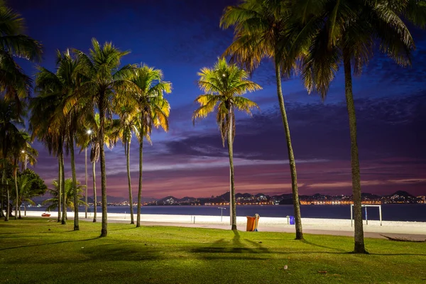 Beautiful view to the sun rising with colorful clouds and palm trees on city beach, Aterro do Flamengo, Rio de Janeiro, Brazil
