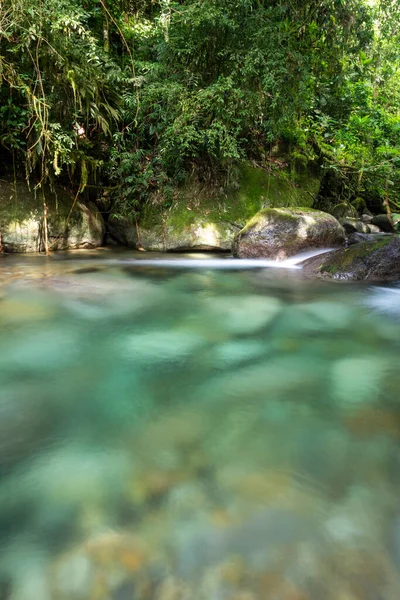 Beautiful crystal clear river with blue water on green rainforest landscape, Serrinha Ecological Reserve in the mountains of Rio de Janeiro, Brazil