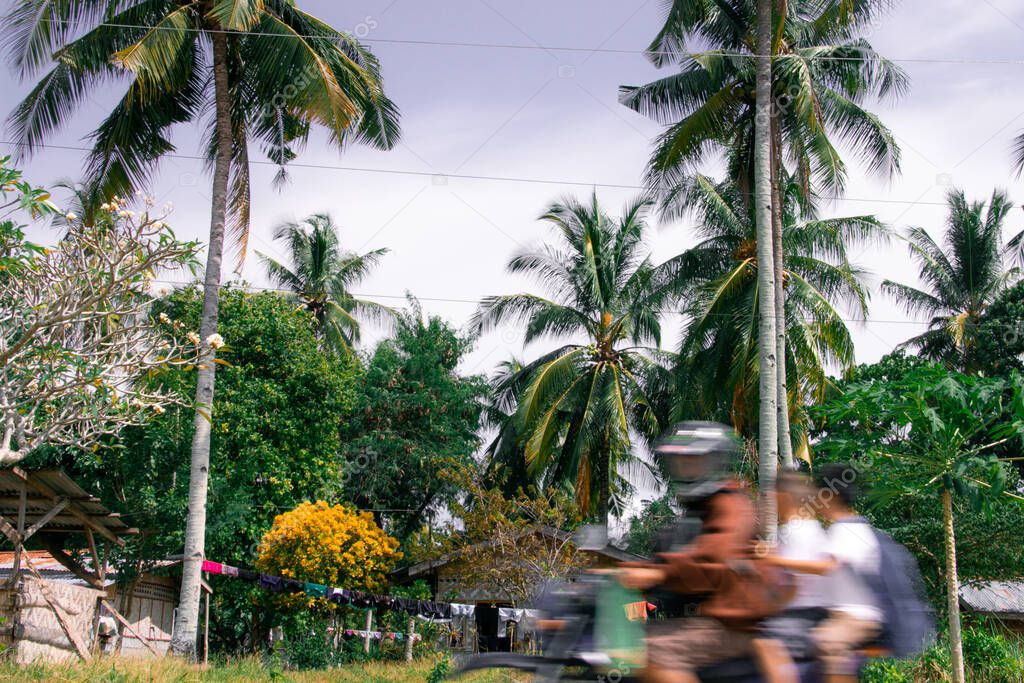 A family of three race home on a motorcycle on Samal Island
