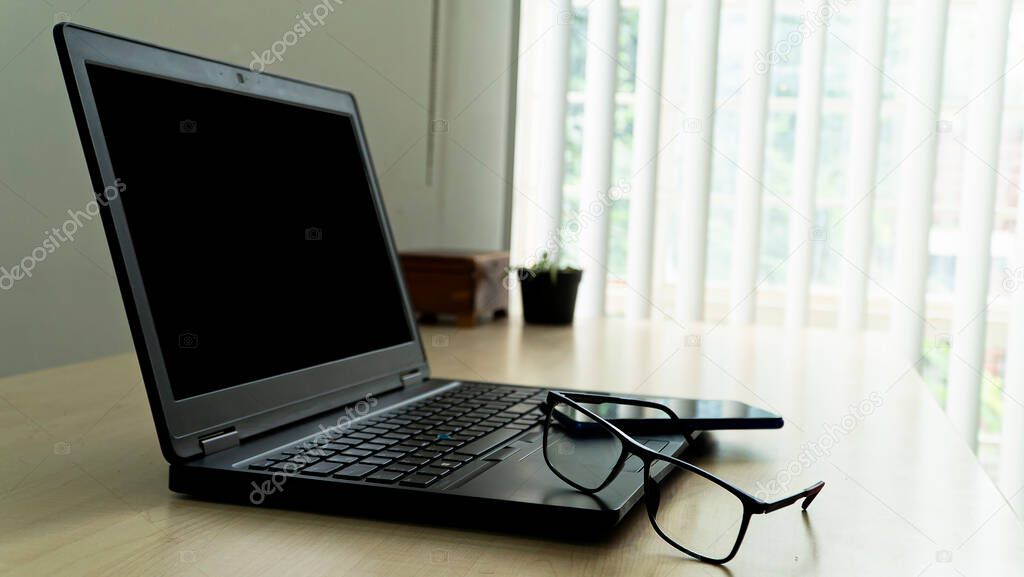 laptop sobre escritorio en oficina con lentes y smarphone. espac