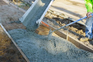 Kaldırımın önündeki çimento yeni kaldırımda inşaat işçisi beton yüzeyi altında yeni bir bina.