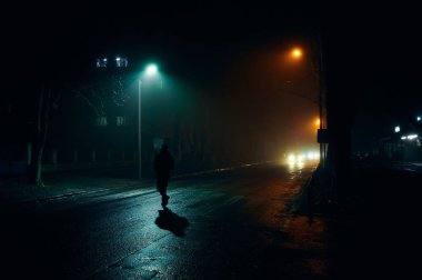 Gece şehrinde bir adamın silueti.
