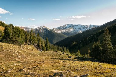 Dağları ve mavi gökyüzü olan güzel bir manzara.