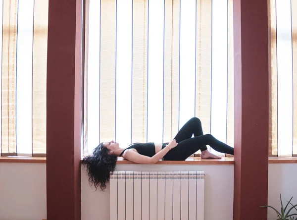 窓の上に横になって音楽を聴いている女の子 — ストック写真