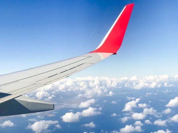 在飞越大海的过程中 在厚厚的白云和蓝天之间飞行时被抓住的飞机翼 — 图库照片