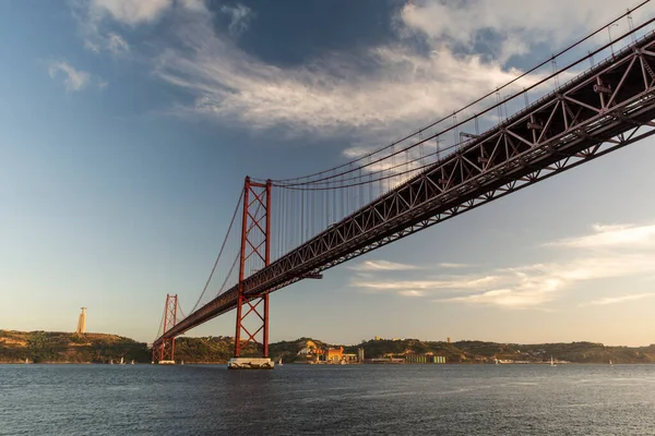 ポルトガルリスボン中心部の日没時にテジョ川を渡る25 Abril BridgeとCristo Reiへの美しい景色 — ストック写真