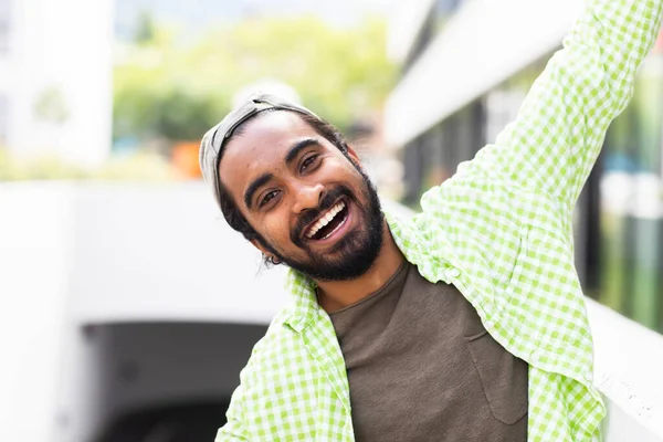 城市背景下穿着绿色衬衫的快乐的印度年轻人的画像 — 图库照片