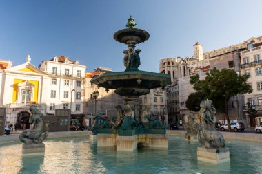 Lizbon, Portekiz 'in merkezindeki tarihi halka açık fıskiye anıtı ve şehir binalarına güzel bir manzara