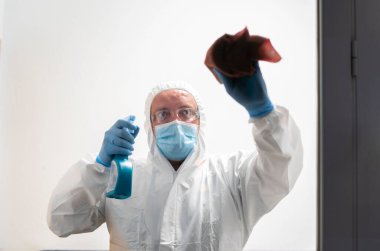 Kovid19 'u önlemek için okul pencerelerini dezenfekte eden temizlik personeli