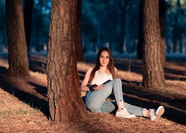 Günbatımında yalnız ormanda çekici genç bir kadın.