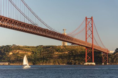 25 de Abril Köprüsü 'nün güzel manzarası Tejo Nehri ve Cristo Rei Heykeli üzerinde gün batımı saatinde, Lizbon, Portekiz şehir merkezi