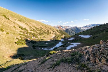 Dağları ve mavi gökyüzü olan güzel bir manzara.