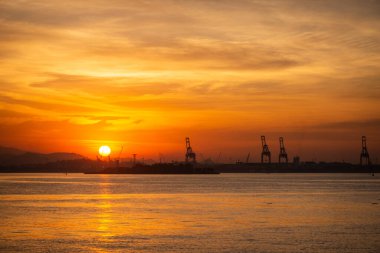 Endüstriyel merkezde, Rio de Janeiro, Brezilya 'da, okyanus kıyısında güneşin batışına güzel bir manzara