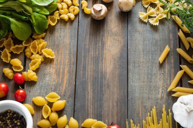 Farklı türde çiğ makarna. İtalyan yemeği. Sağlıklı gıda geçmişi kavramı. Düz yerde, üst tarafta. Yapıştırıcı kopyala.