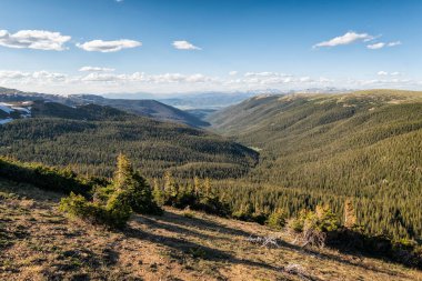 Dağları ve mavi gökyüzü olan güzel bir manzara.