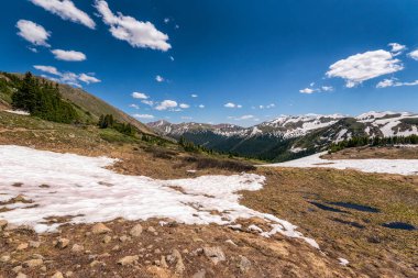 Dağları ve mavi gökyüzü olan güzel bir manzara.