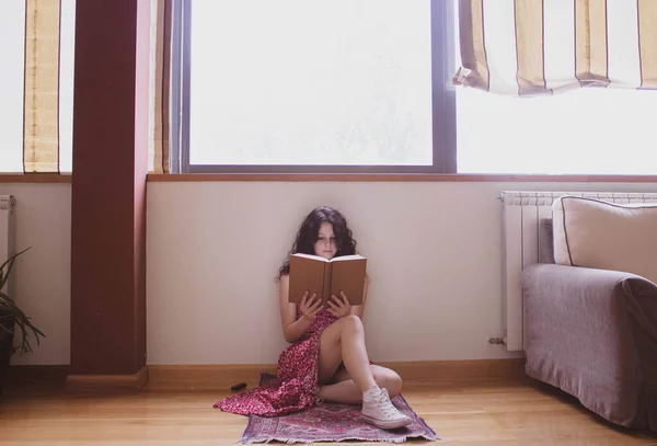 Niña Leyendo Libro Durante Día Cerca Ventana — Foto de Stock