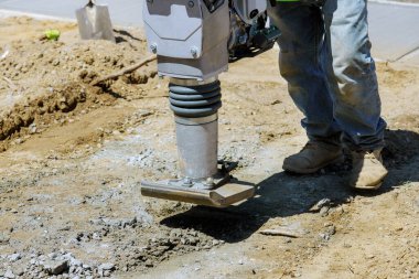 Titreşen çekiç üzerinde kum atlama ile kaldırım boyunca inşaat işlemi