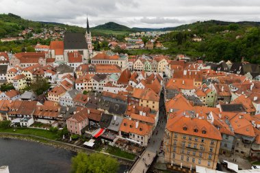 Kilisenin ünlü Cesky Krumlov Şatosu 'nun bulunduğu tarihi Cesky Krumlov şehrinin yukarıdaki panoramik manzara manzarası, ilkbaharda güzel bir gökyüzü ve bulutlarla yakalanan UNESCO Dünya Mirası Alanında yer alıyor.
