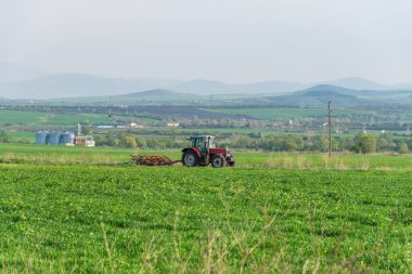 Traktördeki çiftçi tohum ekiciyle toprağı hazırlıyor..