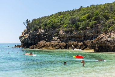 Güneşli bir günde Setubal, Lizbon, Portekiz yakınlarında turistlerle sahile güzel bir manzara.