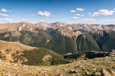 Dağları ve mavi gökyüzü olan güzel bir manzara.