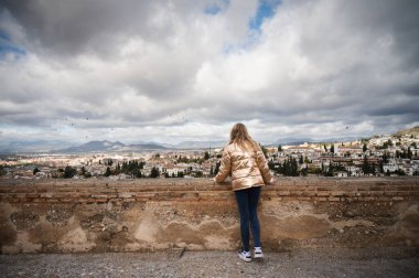 Kumsalda sırt çantalı genç bir kadın.