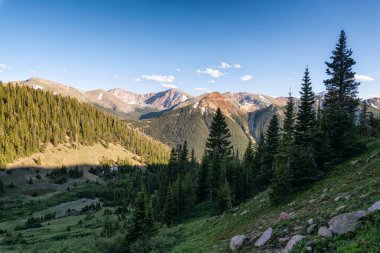 Dağları ve mavi gökyüzü olan güzel bir manzara.