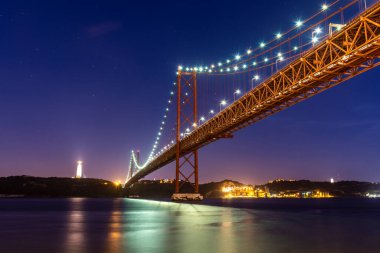 25 de Abril Köprüsü 'nün güzel manzarası Tejo Nehri üzerinde gece erken saatlerde, merkez Lizbon, Portekiz