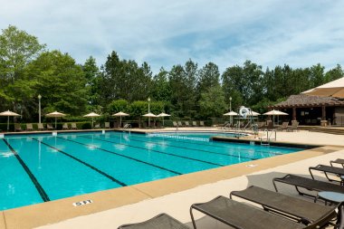 Havuz kenarında sıralanmış yüzme havuzu şezlongları.