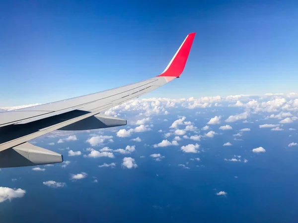 在飞越大海的过程中 在厚厚的白云和蓝天之间飞行时被抓住的飞机翼 — 图库照片
