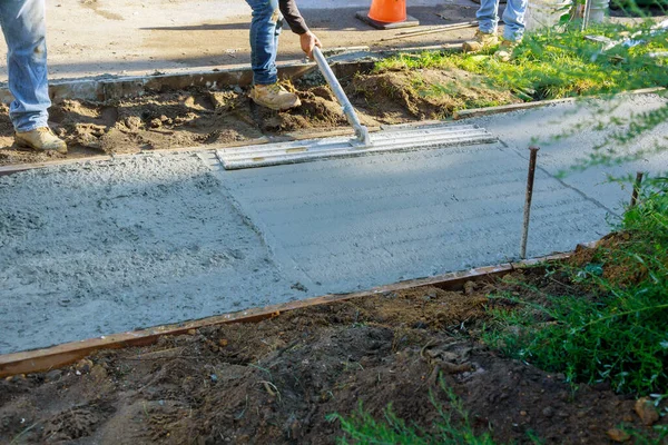 建筑工人在新的水泥人行道上漂浮时 建筑泥瓦匠在水泥路面上施工 — 图库照片