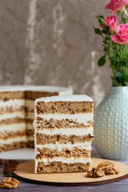 Beyaz kremalı ve fındıklı bir dilim pasta.