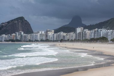 Kuma vuran dalgalara güzel bir manzara ve arkadaki binalara Copacabana Sahili, Rio de Janeiro, Brezilya