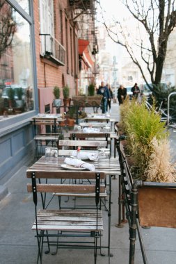 Restoran masaları ve sandalyeler sokakta.