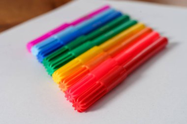 Beyaz çarşaf ve kahverengi masa üzerindeki renkli işaretler.