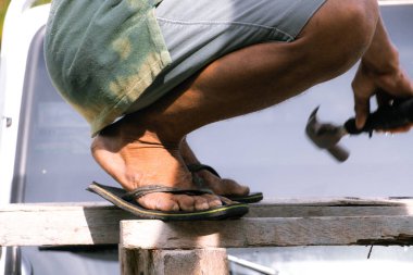 İşçi çekiçle metal kesiyor.