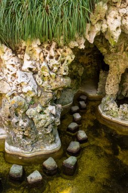 Quinta da Regaleira, Sintra 'da, Lizbon, Portekiz yakınlarındaki su üzerinde taş basamakları olan bahçe nehrine güzel bir manzara.