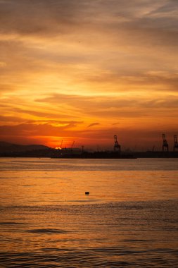 Endüstriyel merkezde, Rio de Janeiro, Brezilya 'da, okyanus kıyısında güneşin batışına güzel bir manzara