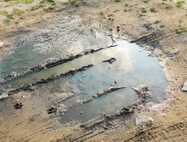 Lastik izi olan çamur ve su birikintisi. Çamurlu arazi, yağmurdan sonra toprak yol. Yolların Dayanıklılığı. Çaresizlik kavramı