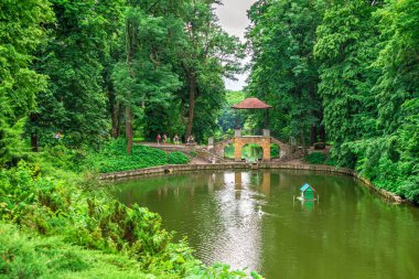 Bila Tserkva, Ukrayna 06.20.2020. Ukrayna 'nın en güzel ve ünlü ağaç kesimlerinden biri olan İskenderiye parkındaki Çin köprüsü, bulutlu bir yaz gününde..