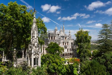 Lizbon, Portekiz yakınlarındaki Quinta da Regaleira, Sintra 'da yeşil ağaçlı eski tarihi sarayın ve şapel kulelerinin güzel manzarası.