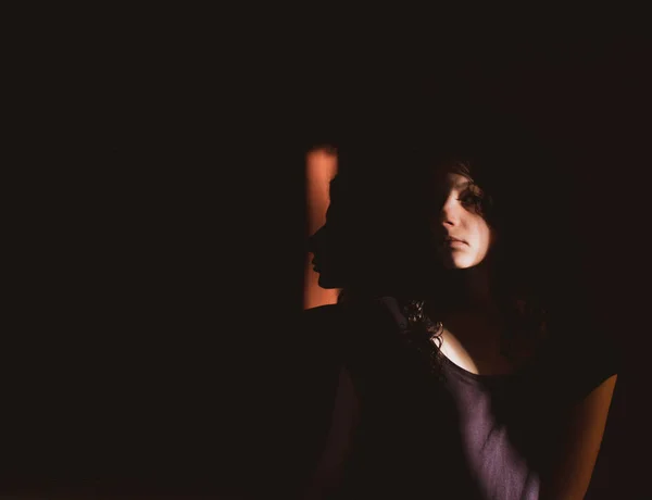 Νεαρή Γυναίκα Μαύρο Φόντο Φως Και Σκιές Στο Πρόσωπό Της — Φωτογραφία Αρχείου