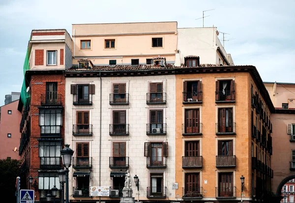マドリードの通りに位置するカラフルな壁やバルコニー付き高齢者住宅の石造りの建物の低角度外観 — ストック写真